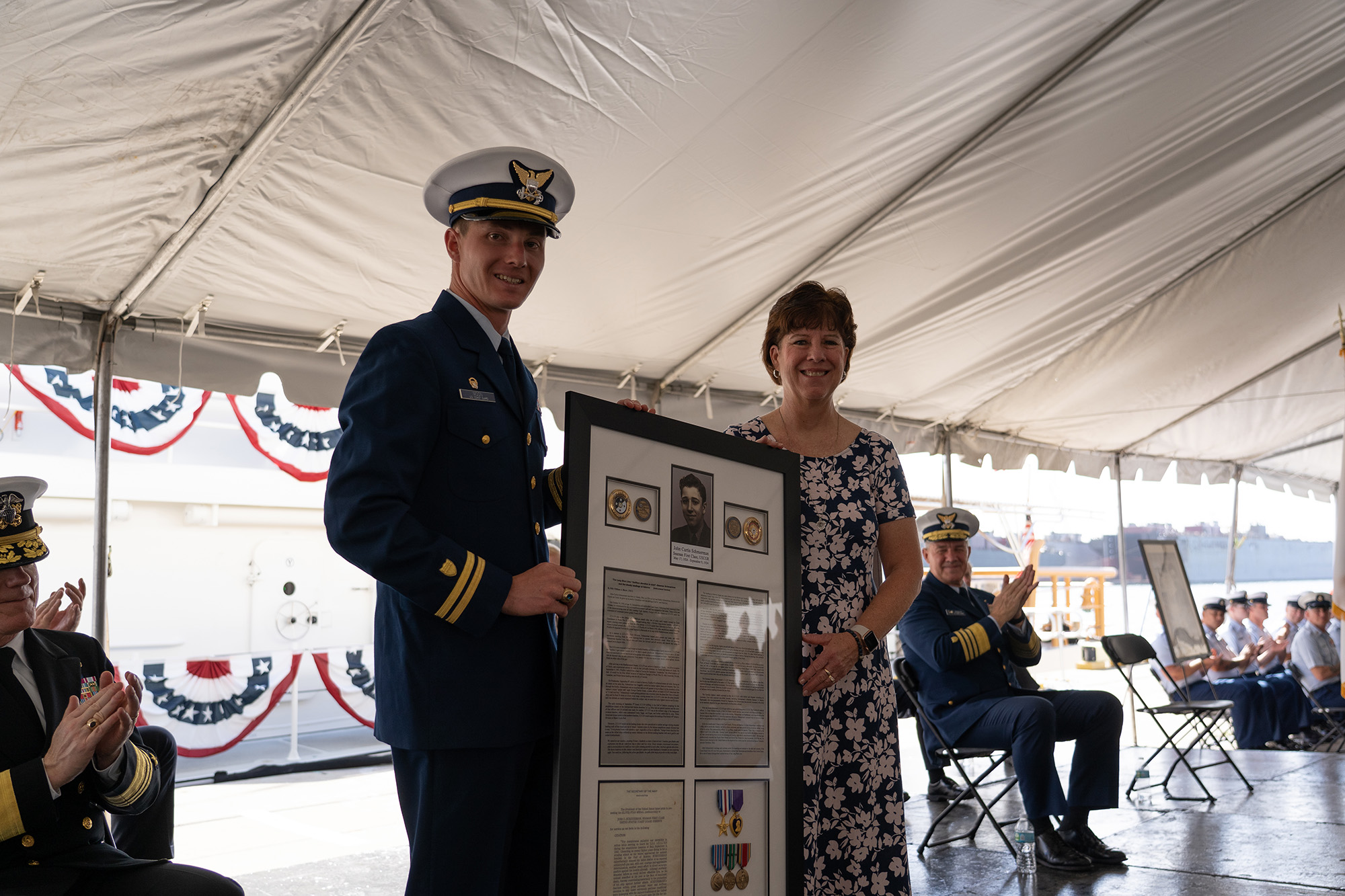 The Coast Guard Cutter John Scheuerman's commanding officer, Lt. Trent Moon, and the ship's sponsor, Mrs. Nancy Vannoy, pose for a photo commissioning ceremony in Tampa, Florida, Feb. 23, 2022. The John Scheuerman is the 46th Sentinel-class fast response cutter and the fifth of six FRC's to be homeported in Manama, Bahrain, which will replace the aging 110’ Island Class Patrol Boats. Photo: U.S. Coast Guard