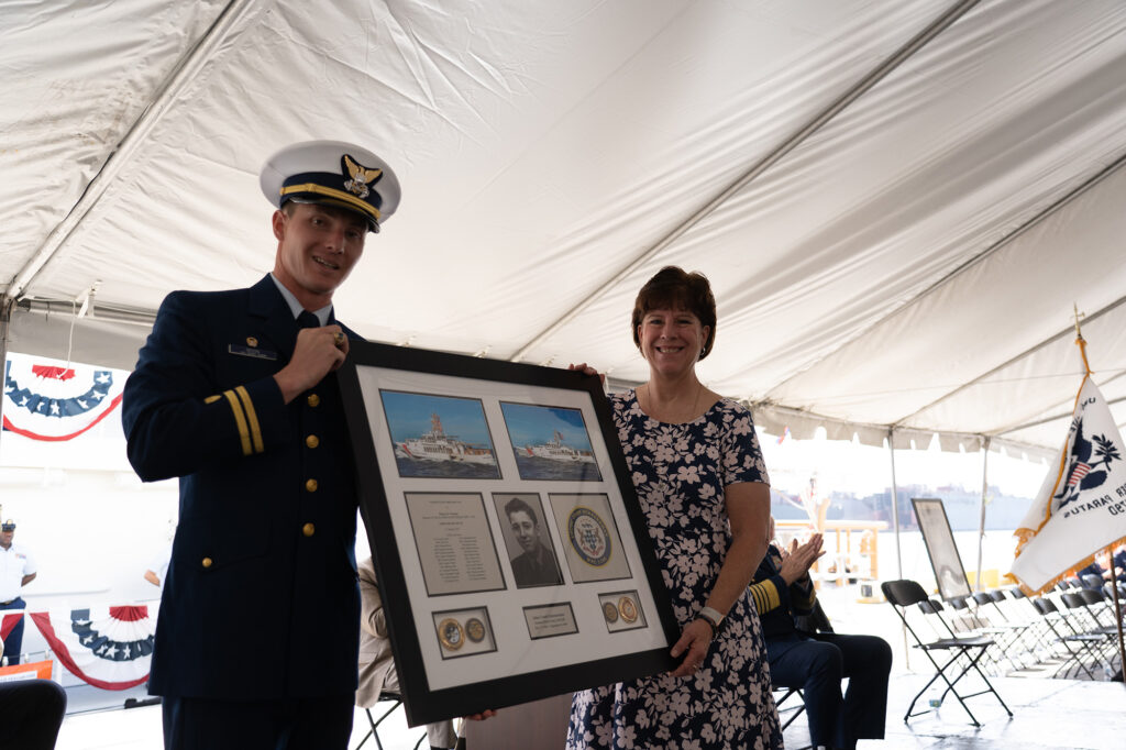 The Coast Guard Cutter John Scheuerman's commanding officer, Lt. Trent Moon, and the ship's sponsor, Mrs. Nancy Vannoy, pose for a photo during the commissioning ceremony in Tampa, Florida, Feb. 23, 2022. The John Scheuerman is the 46th Sentinel-class fast response cutter and the fifth of six FRC's to be homeported in Manama, Bahrain, which will replace the aging 110’ Island Class Patrol Boats. Photo: U.S. Coast Guard